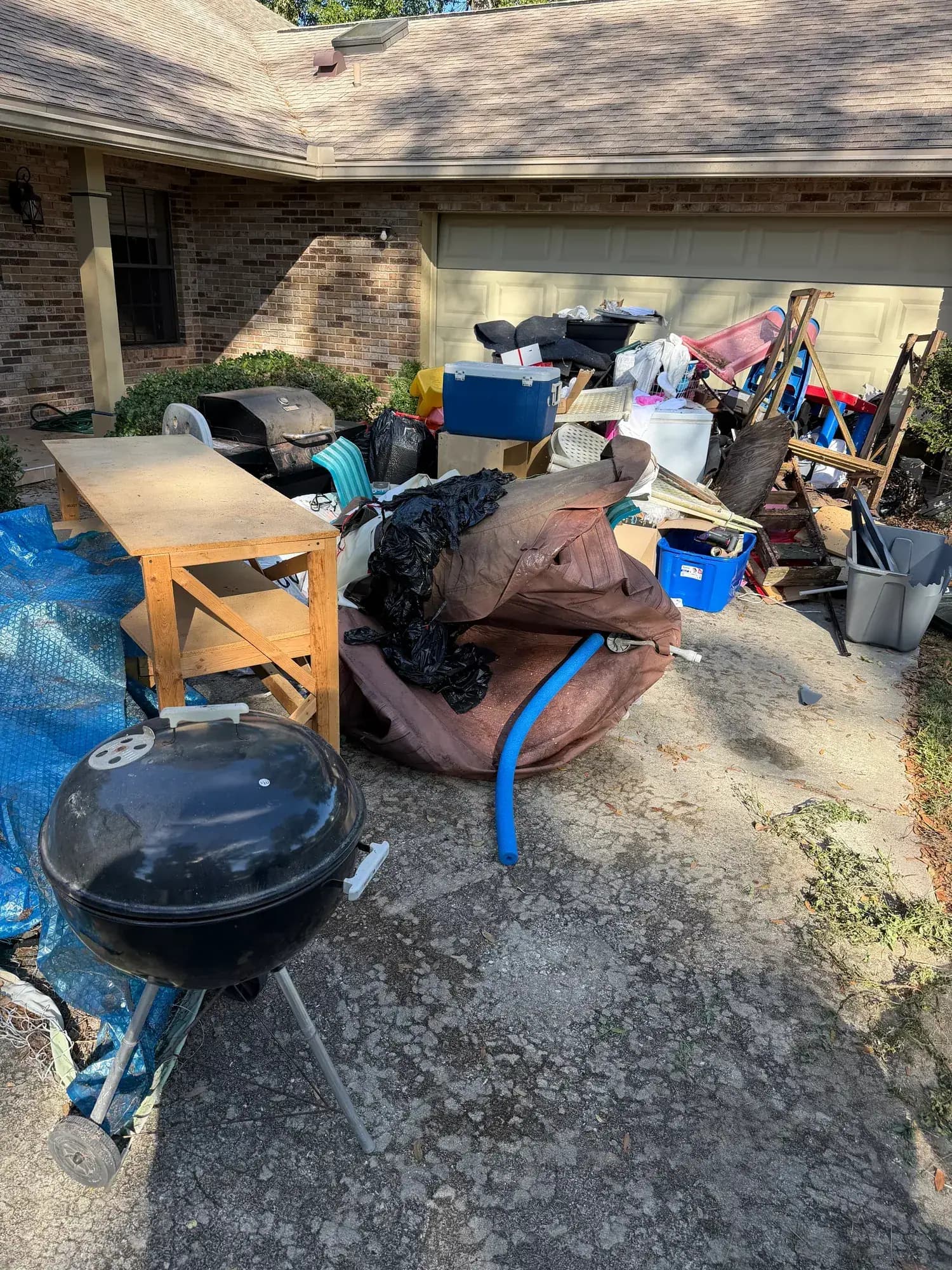 Before: a garage's worth of junk piled on an Orange County, FL driveway before Big Rob's Hauling arrived