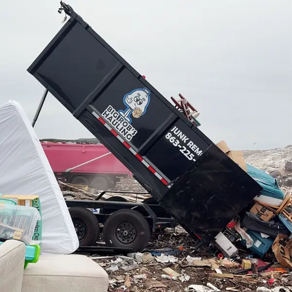 Big Rob's Hauling dump trailer unloading a mattress and furniture at a Central Florida landfill