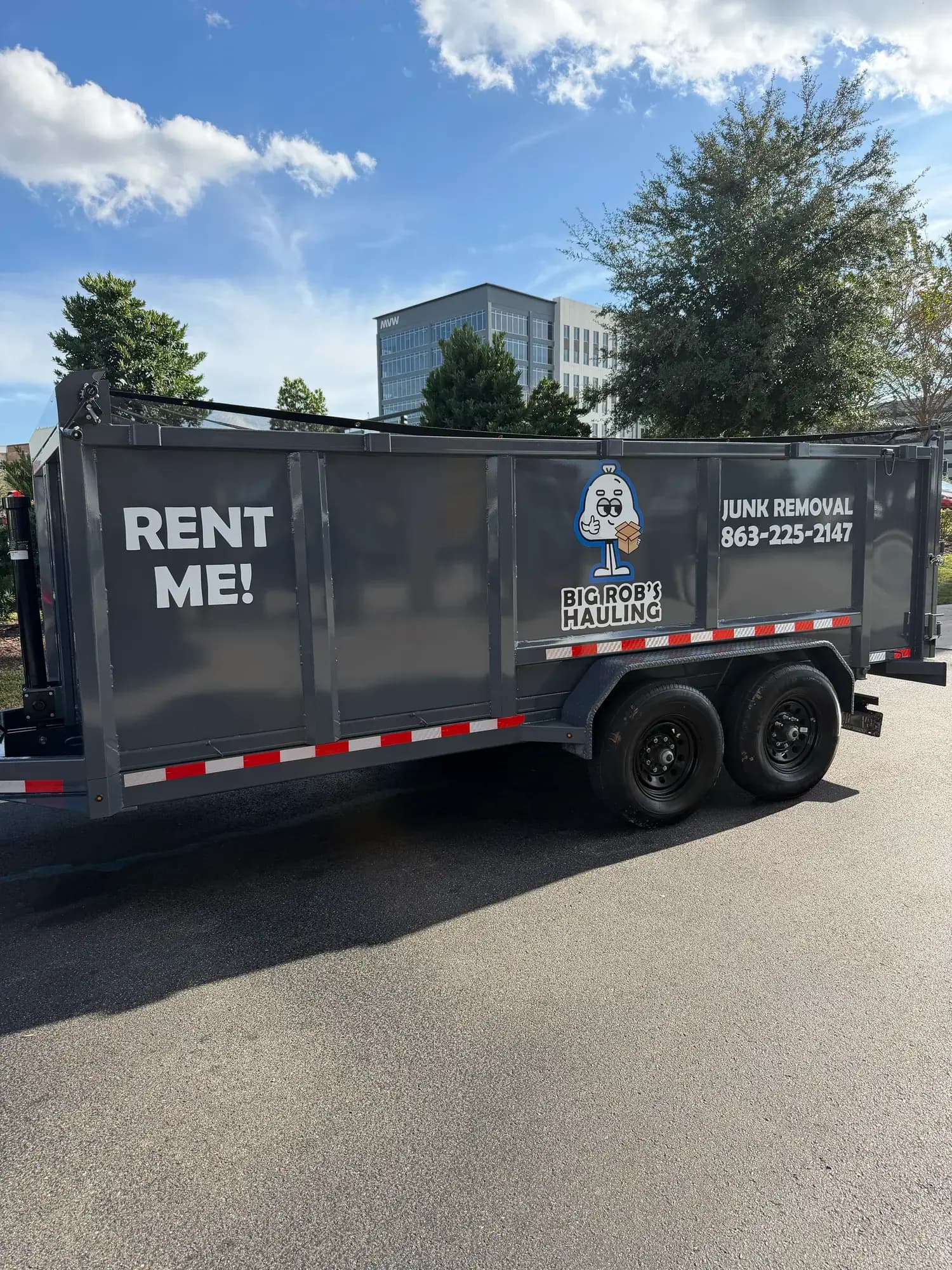 Side of a Big Rob's Hauling Rent Me dump trailer parked on an Orlando, FL street, (863) 225-2147 on the panel