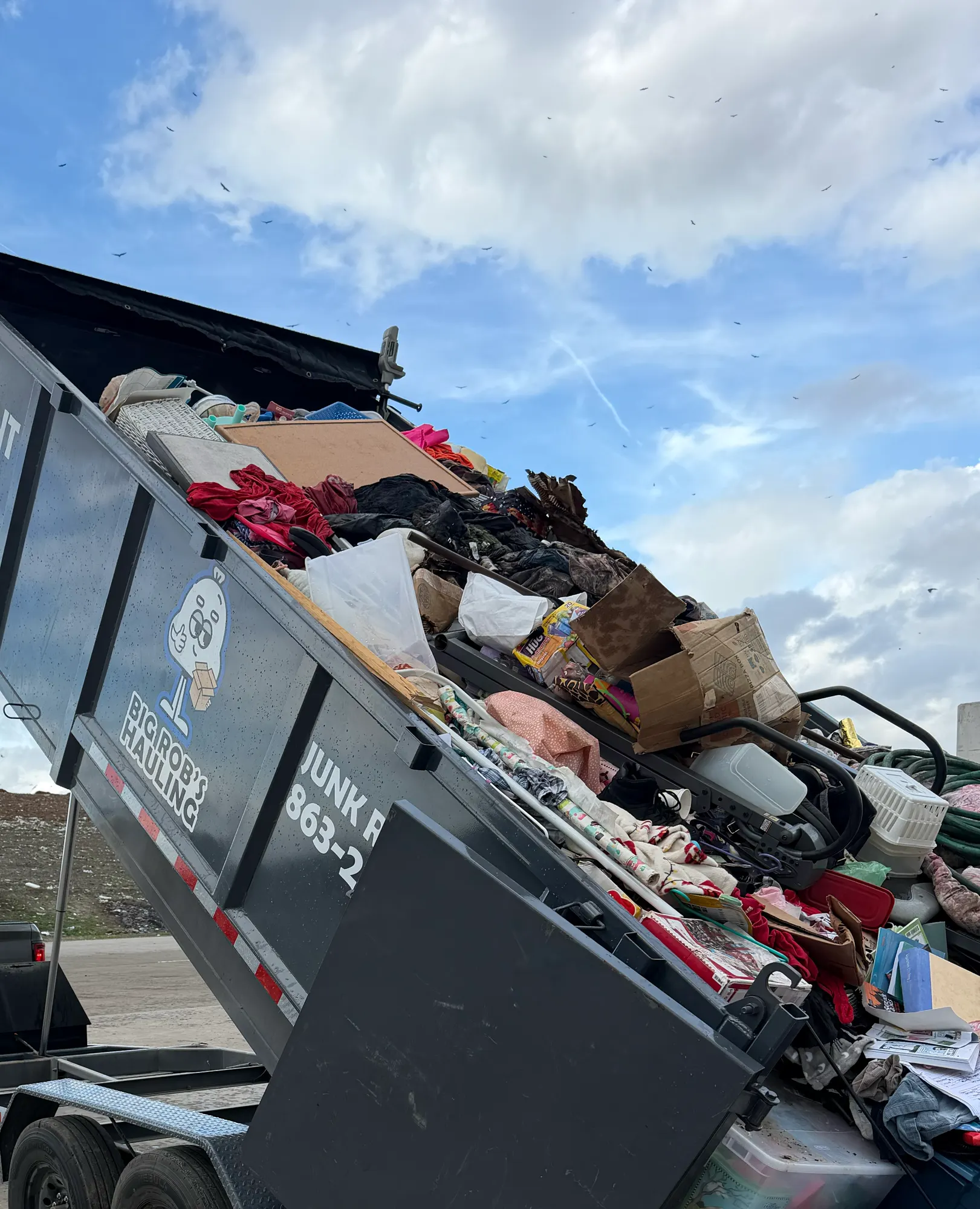 Big Rob's Hauling dump trailer tipping a full junk load at a Central Florida landfill