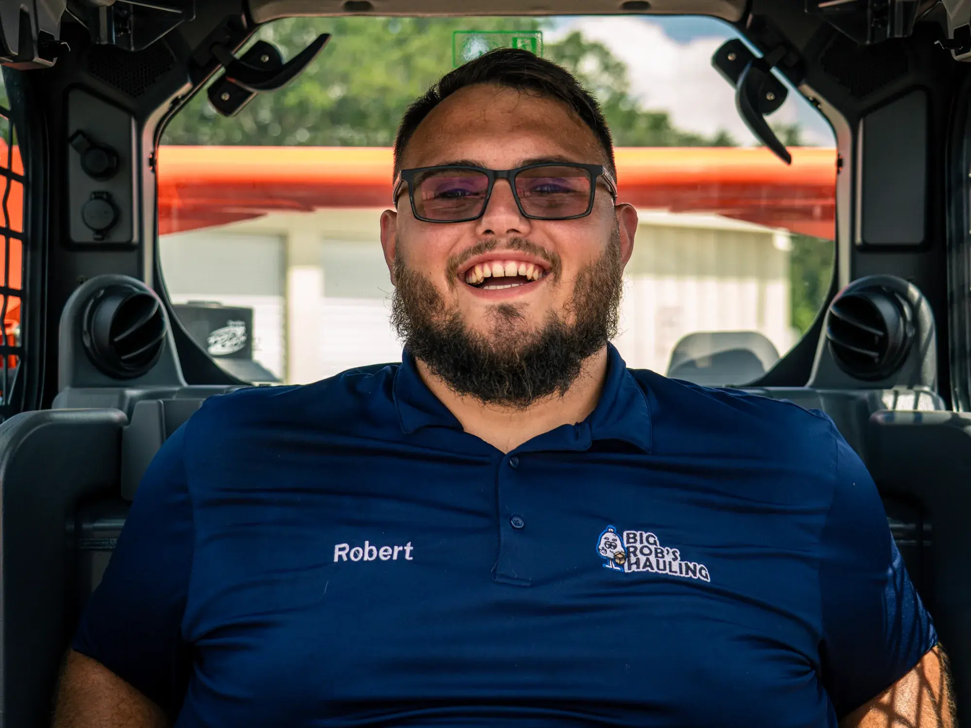 Rob, owner-operator of Big Rob's Hauling in Davenport, FL, laughing in the cab of his Kubota skid steer