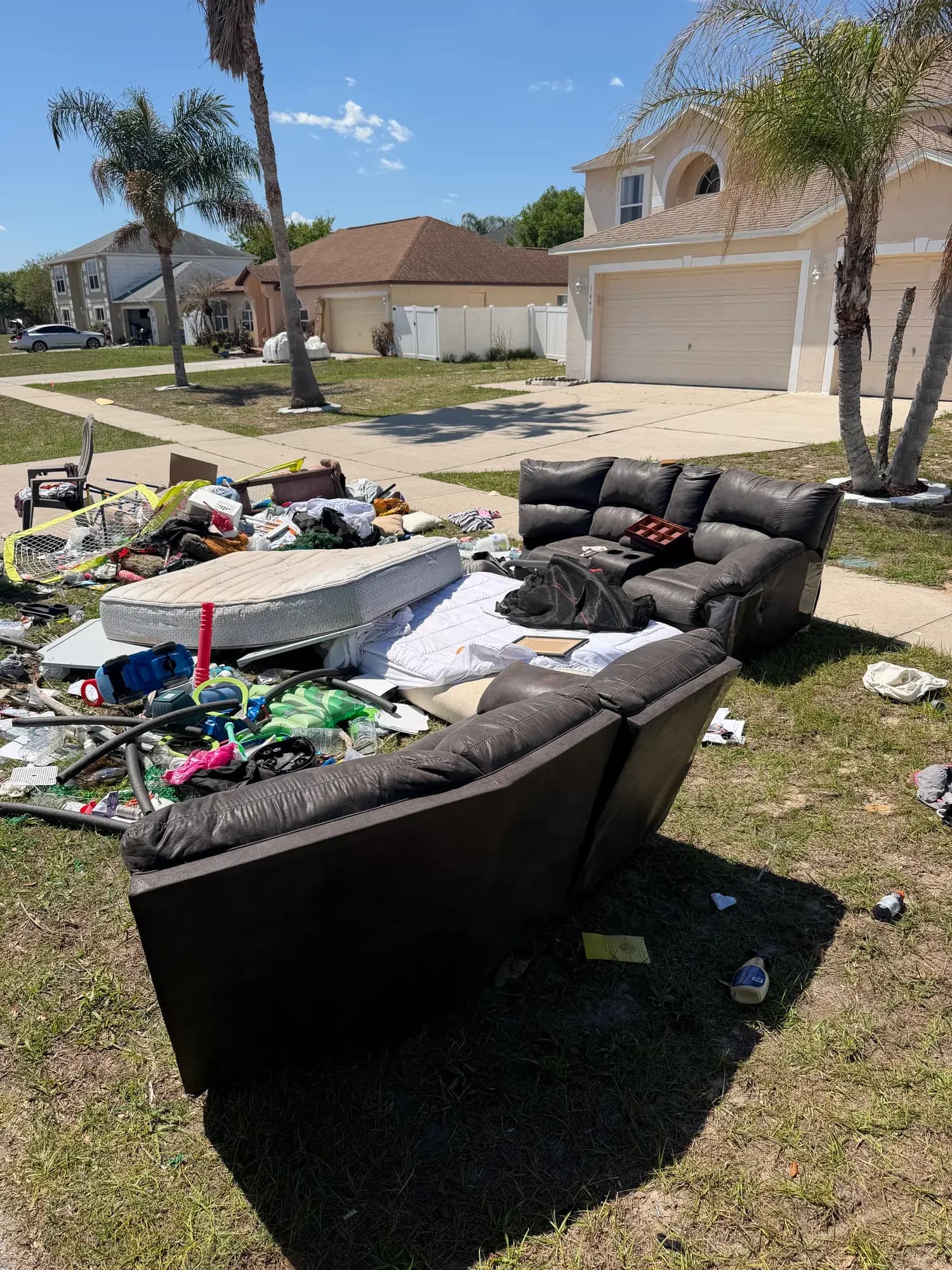 Before: sectional, mattress and household junk piled on a Mascotte, FL lawn