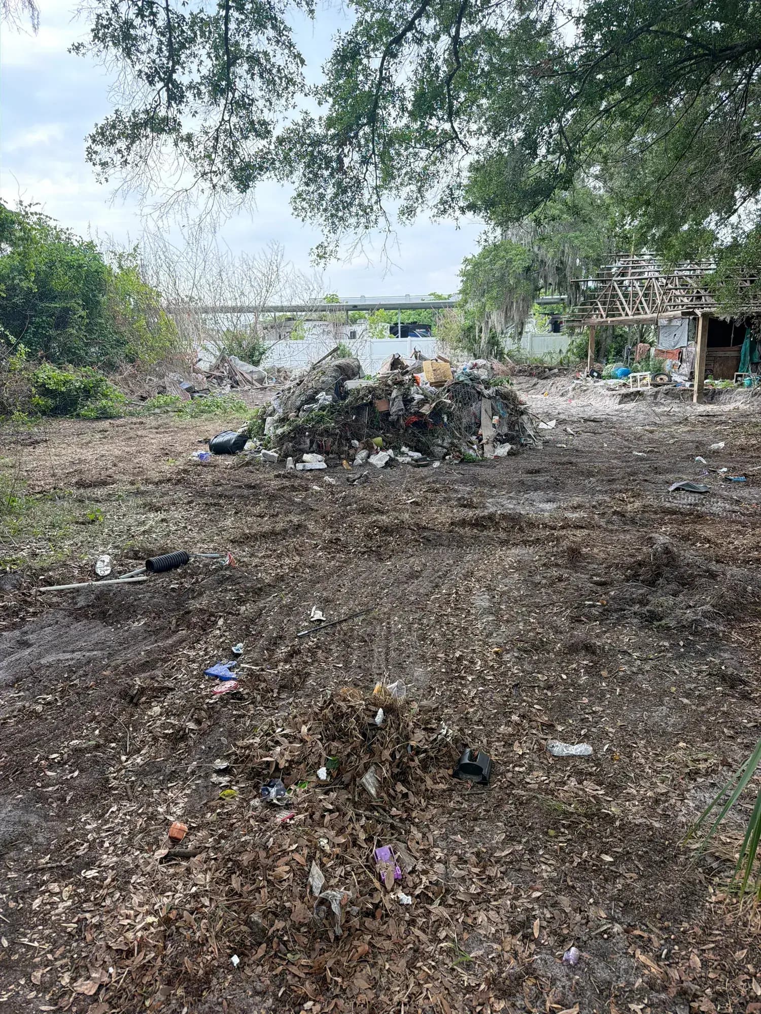 Before: debris piled on a Lakeland, FL lot beside an old pavilion frame