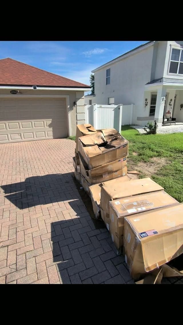 Stacked boxes on a Davenport, FL driveway from a same-day solar contractor debris pickup by Big Rob's Hauling