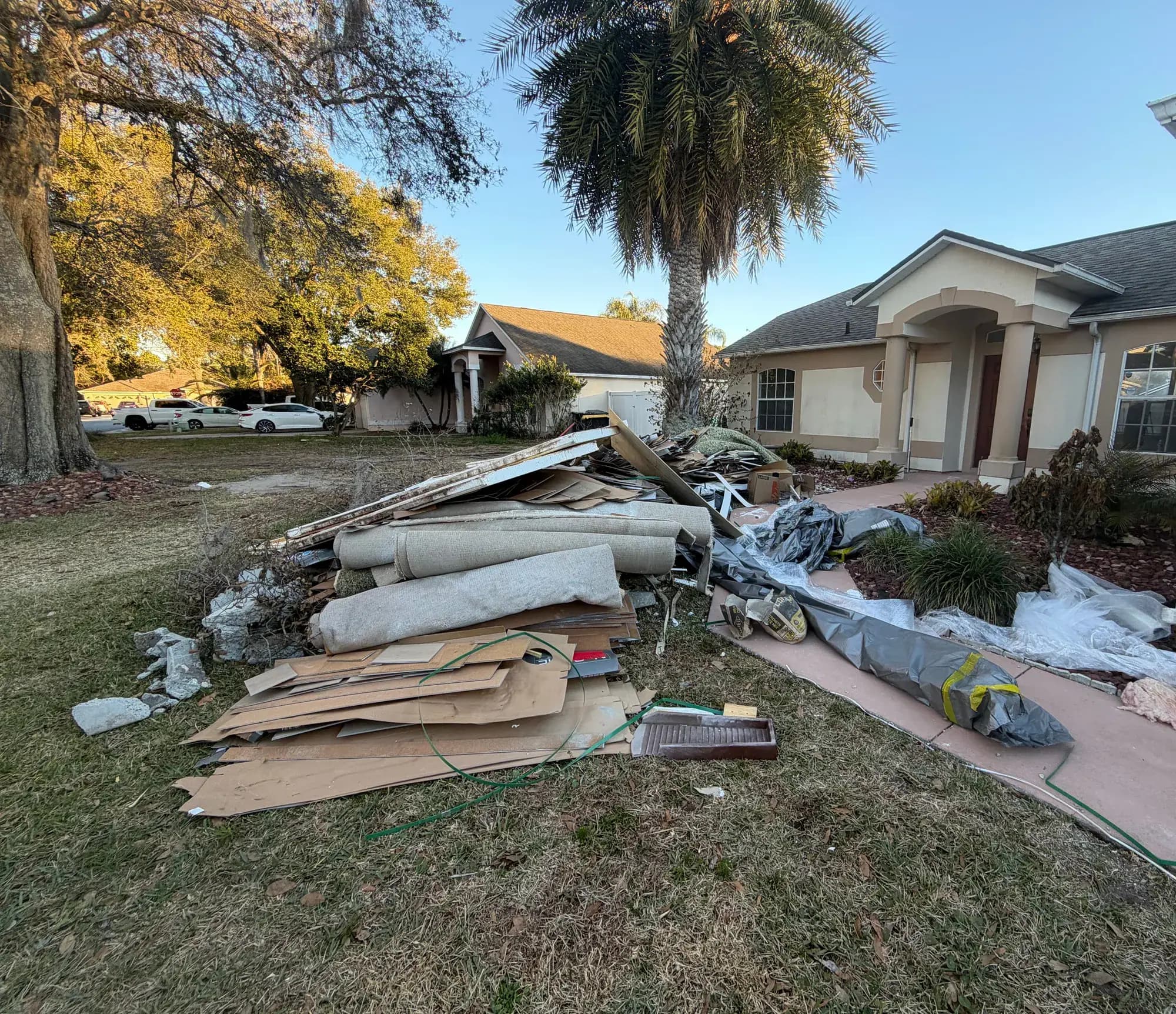 Drywall, carpet and lumber from a remodel piled on the lawn for Big Rob's Hauling in ChampionsGate, FL