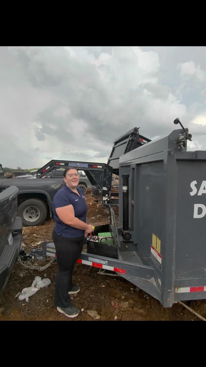 Sarah of Big Rob's Hauling beside the Same Day dump trailer and truck at a Central Florida landfill