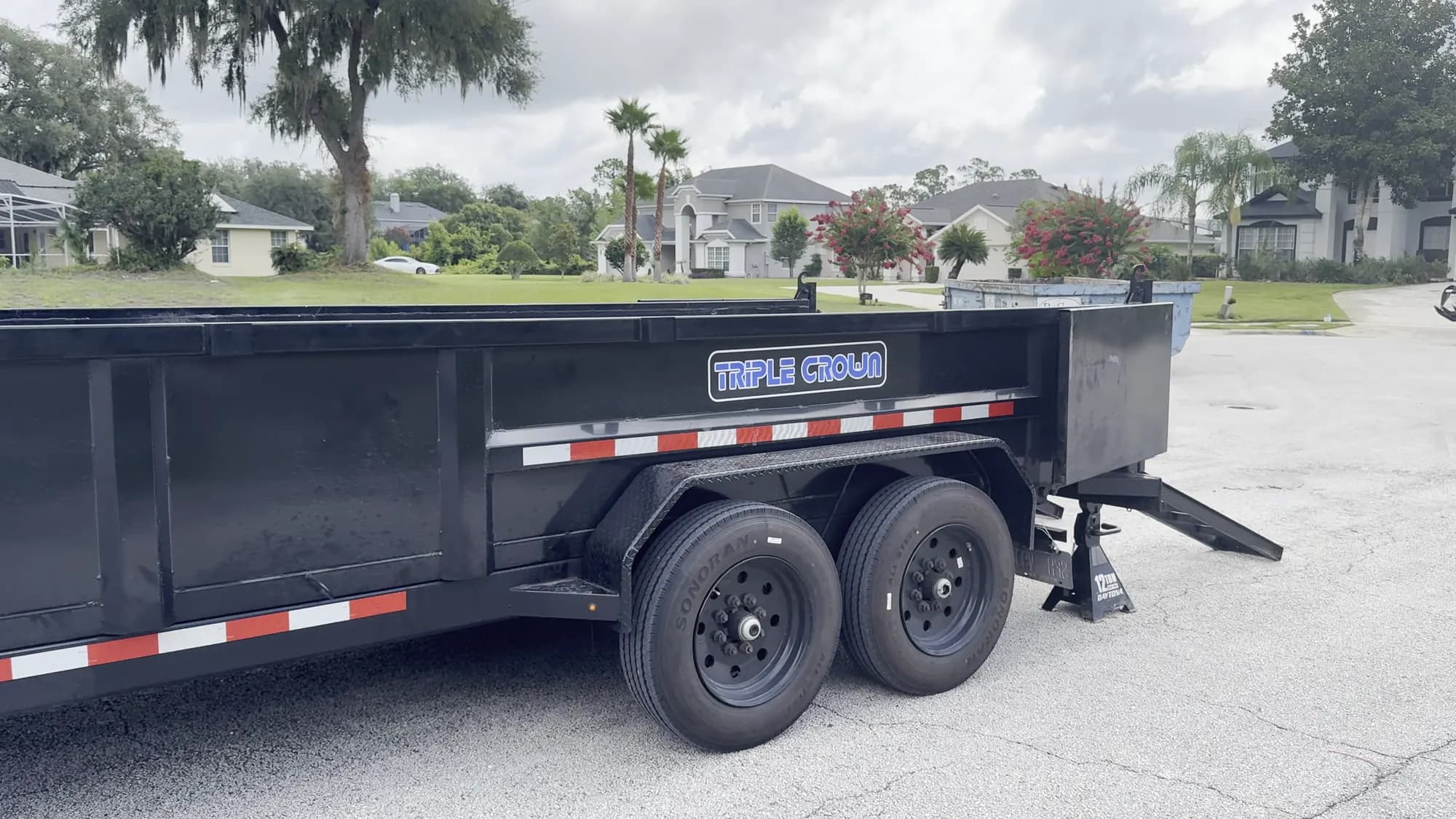 Big Rob's Hauling black dump trailer hitched to the truck on a Central Florida cul-de-sac before a haul