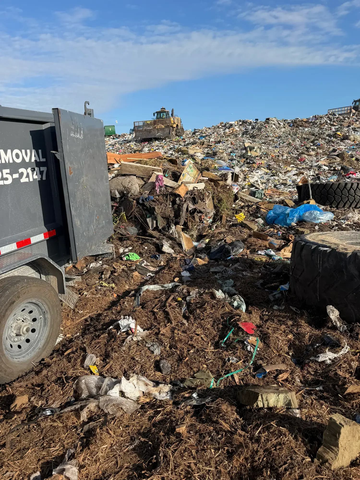 Big Rob's Hauling dump trailer unloading at a Polk County, FL landfill with the dozer working the face behind