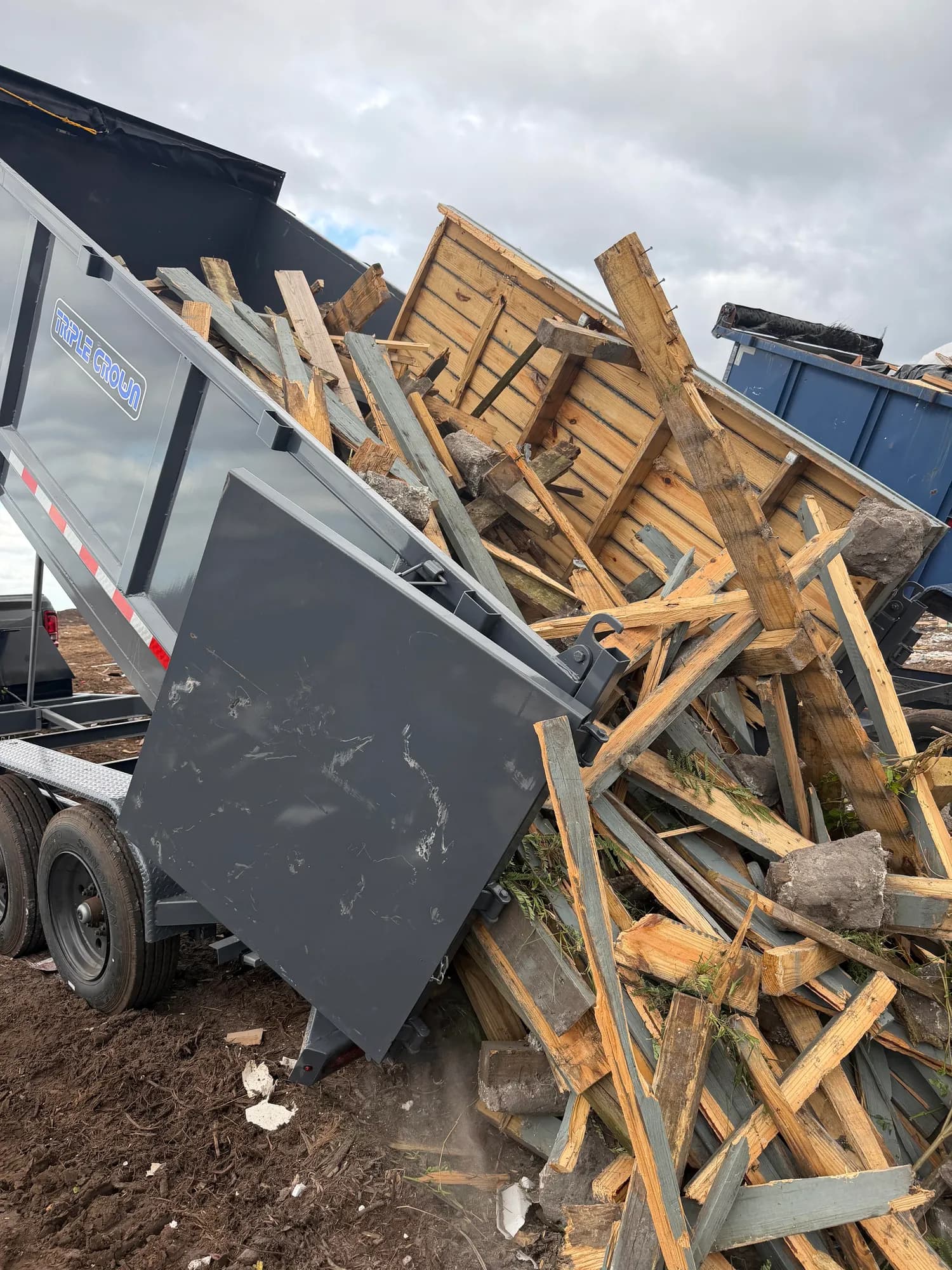 Old fence panels and posts tipped out of the Big Rob's Hauling dump trailer at a Central Florida landfill