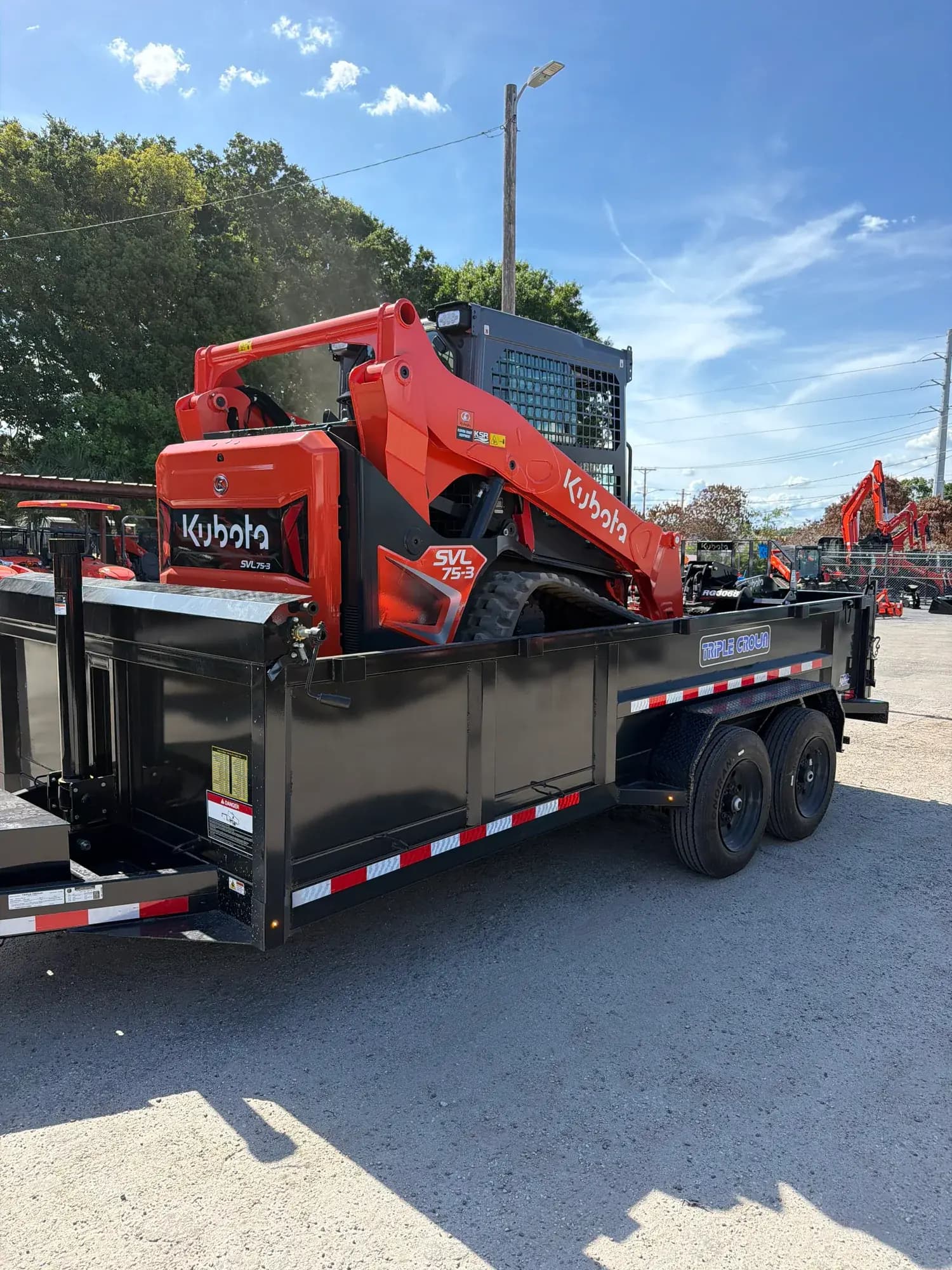 Kubota skid steer loaded on a Big Rob's Hauling dump trailer, ready to roll in Polk County, FL
